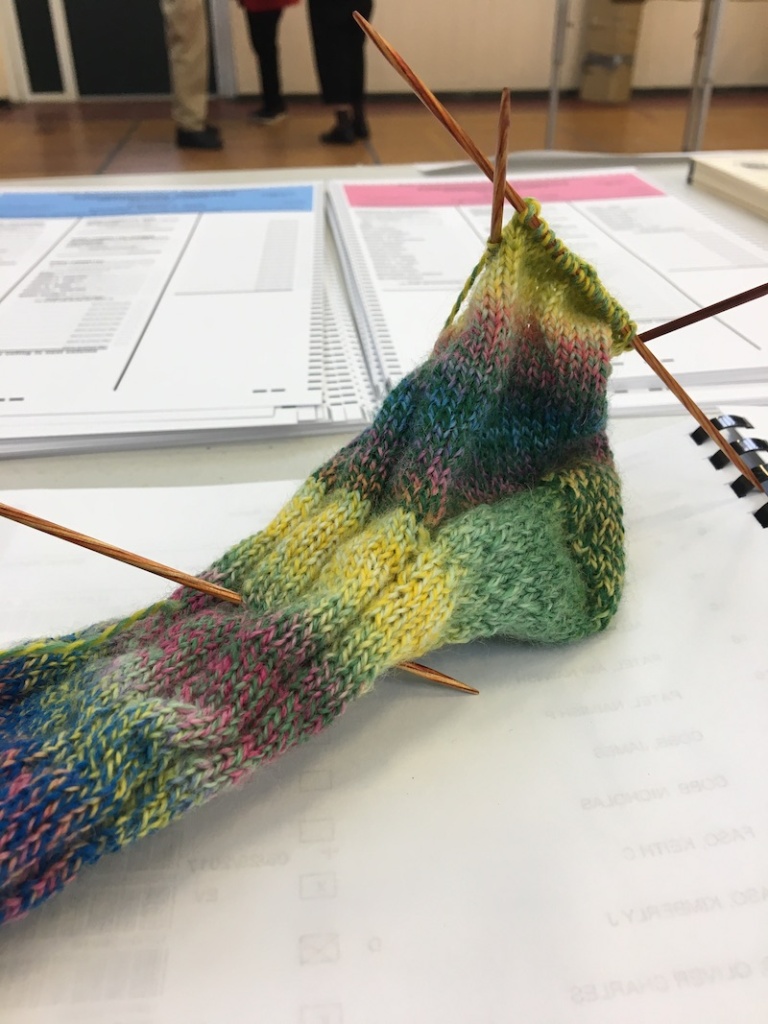 brightly colored knit sock on double-pointed needles 